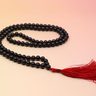 Garnet 108 Mala Necklace on pink and orange background