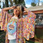 Woman wearing a patterned kimono over a white graphic tee.