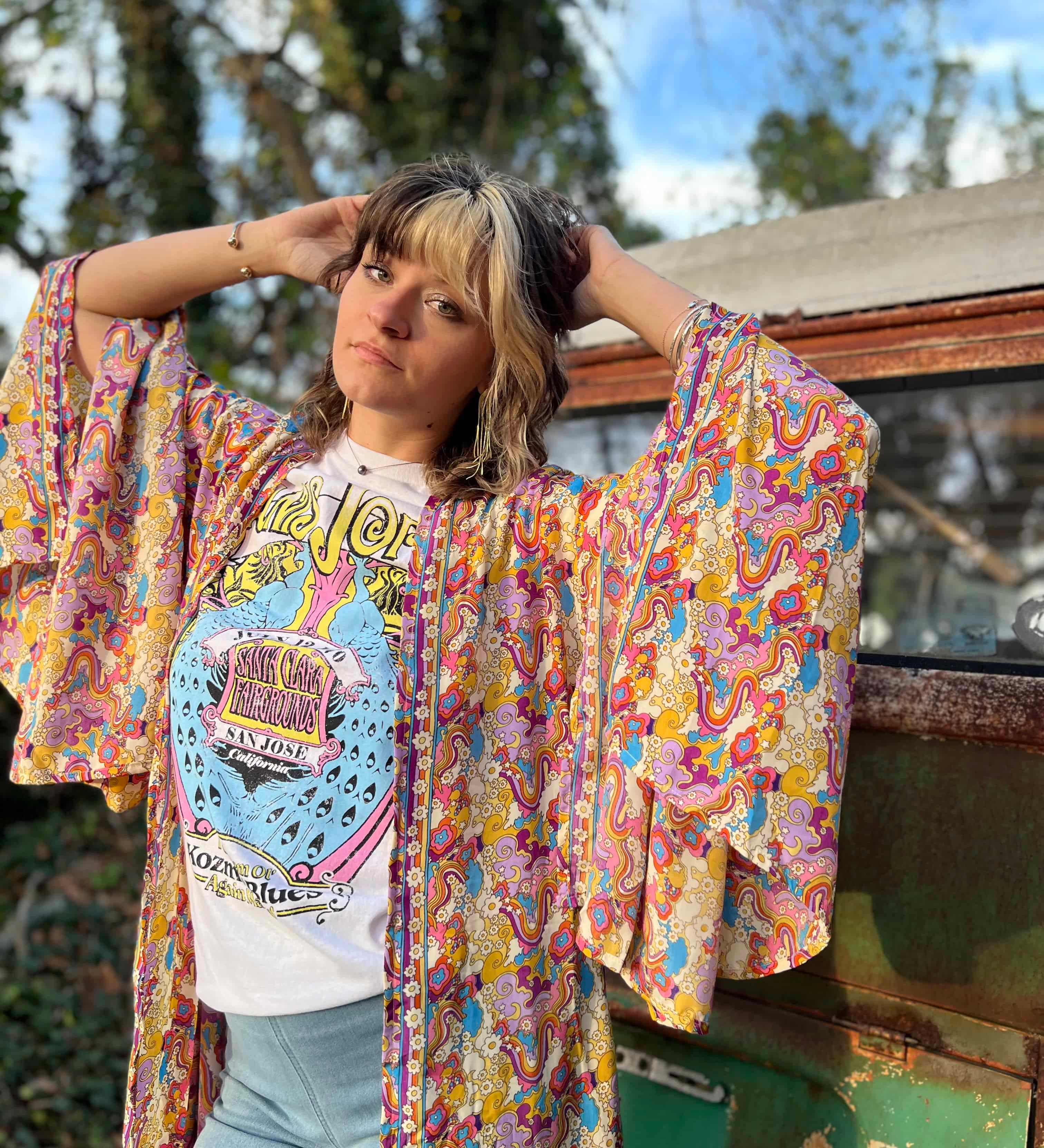 Woman wearing a patterned kimono over a white graphic tee.
