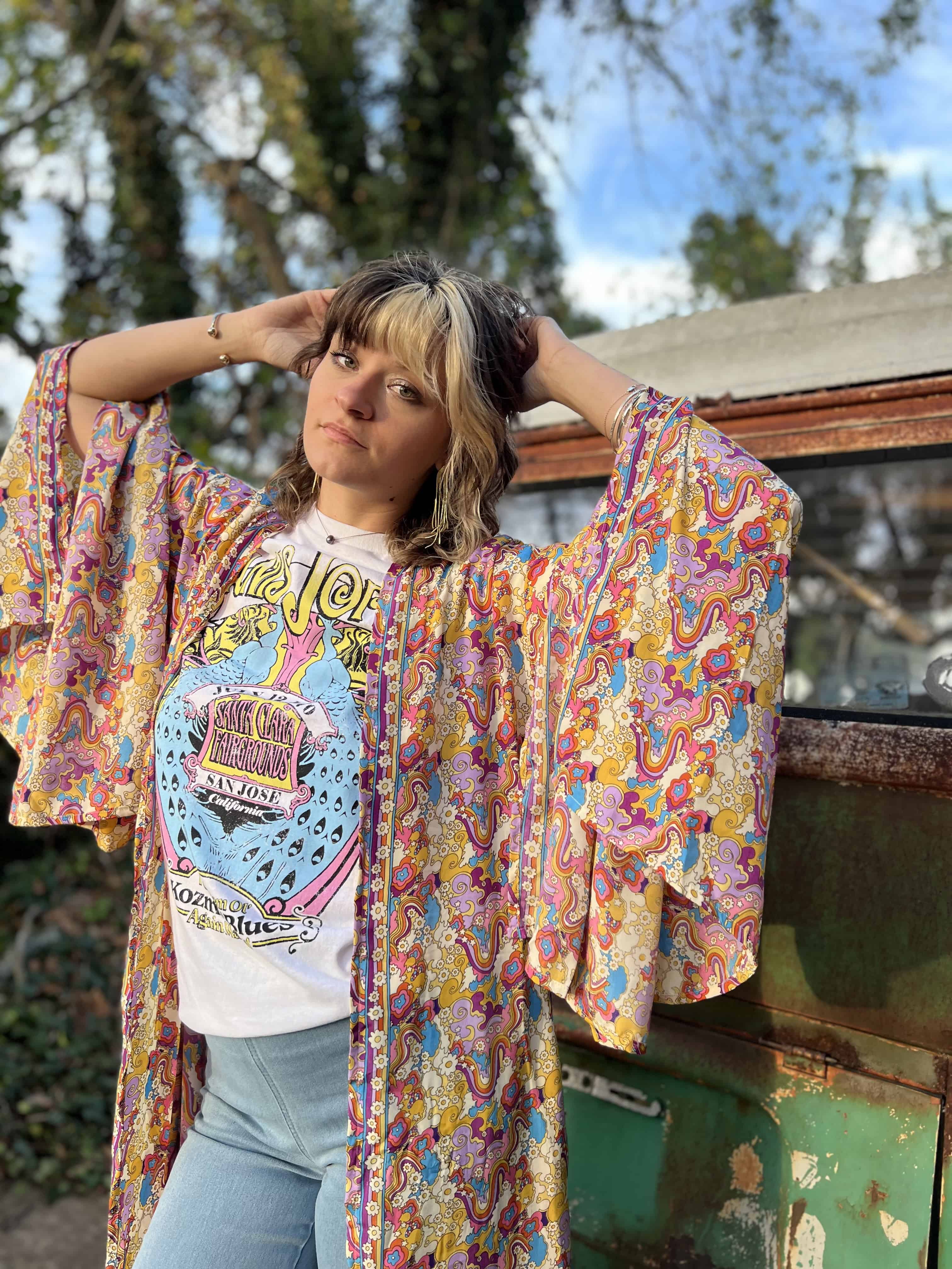 Woman wearing a patterned kimono over a white graphic tee.