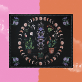 The Succulent Moon Phases Wall Tapestry on a pink and orange background.