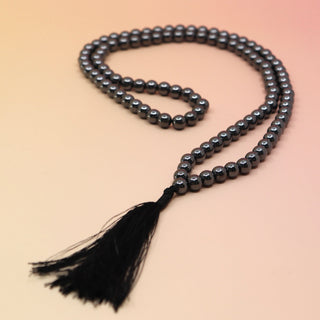Hematite 108 Mala Necklace on pink and orange background
