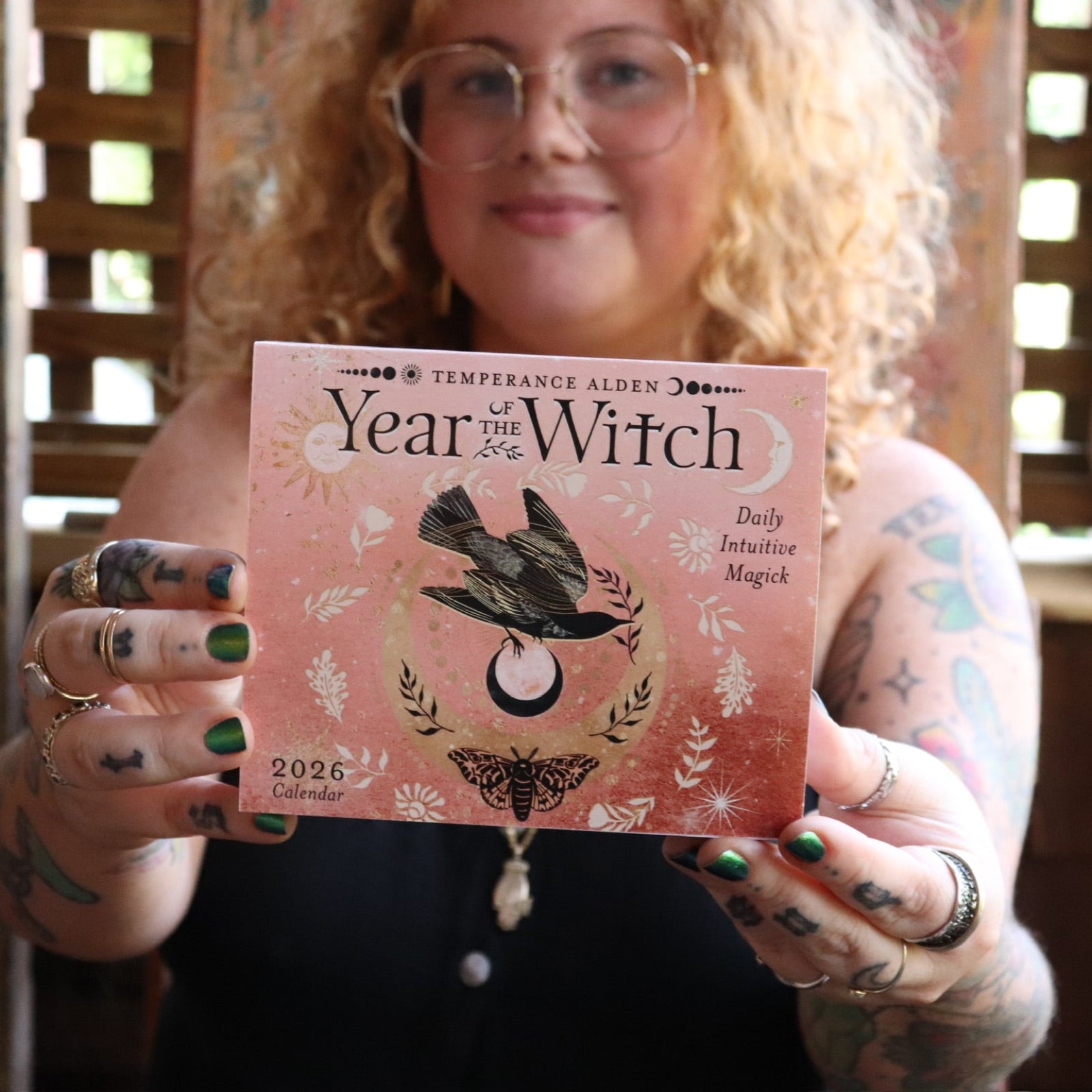 Someone holding the Year of the Witch 2026 Day-to-Day Calendar up in front of them.