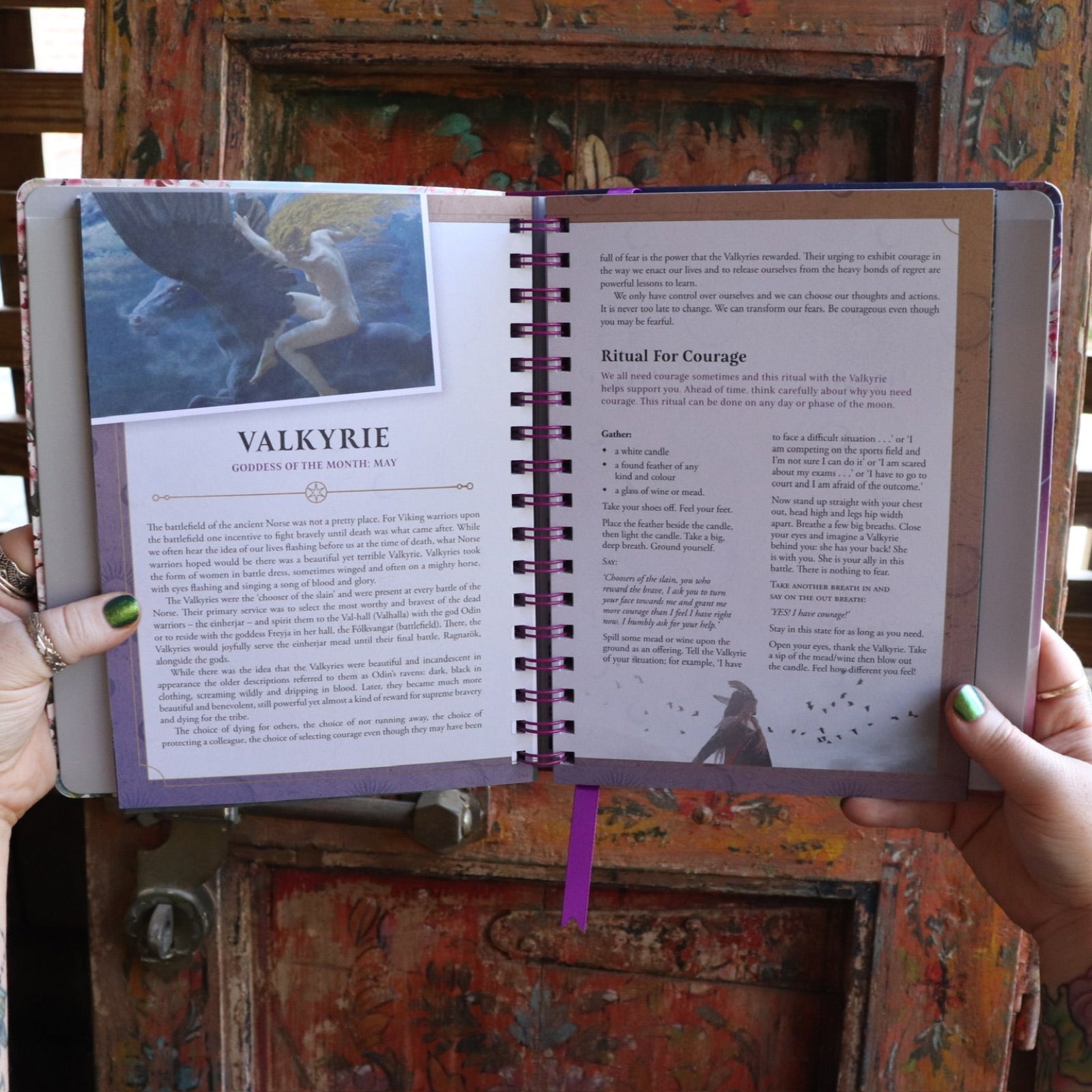 Someone holding the 2026 Lunar and Seasonal Northern Hemisphere Planner Calendar open in front of a wooden door, showing off the pages.