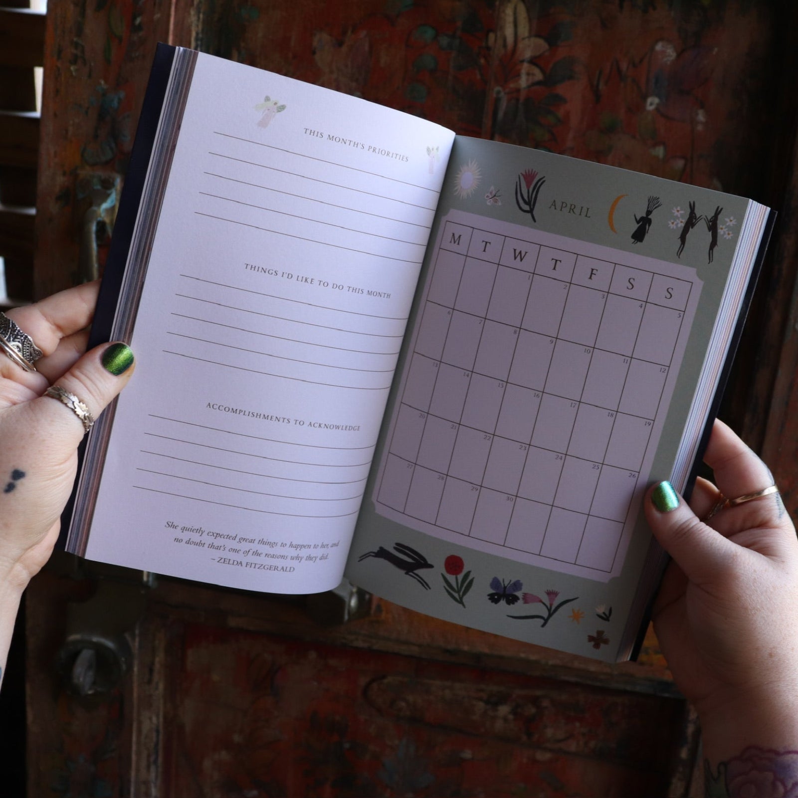 Someone holding the 2026 Seasons of the Witch Planner Calendar, showing off the pages.