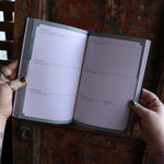 Someone holding the 2026 Seasons of the Witch Planner Calendar, showing off the pages.