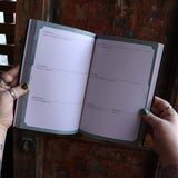 Someone holding the 2026 Seasons of the Witch Planner Calendar, showing off the pages.