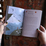 Someone holding the 2026 Seasons of the Witch Planner Calendar, showing off the pages.