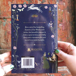 Someone holding the 2026 Seasons of the Witch Planner Calendar, showing off the back.