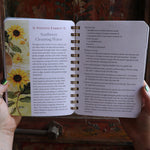 Someone holding the Year of the Witch 2026 Weekly Planner in front of a door, showing off the pages.