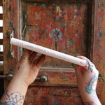Someone holding the 2026 Moon Goddess Northern Hemisphere Planner Calendar in front of a wooden door, showing off the side.