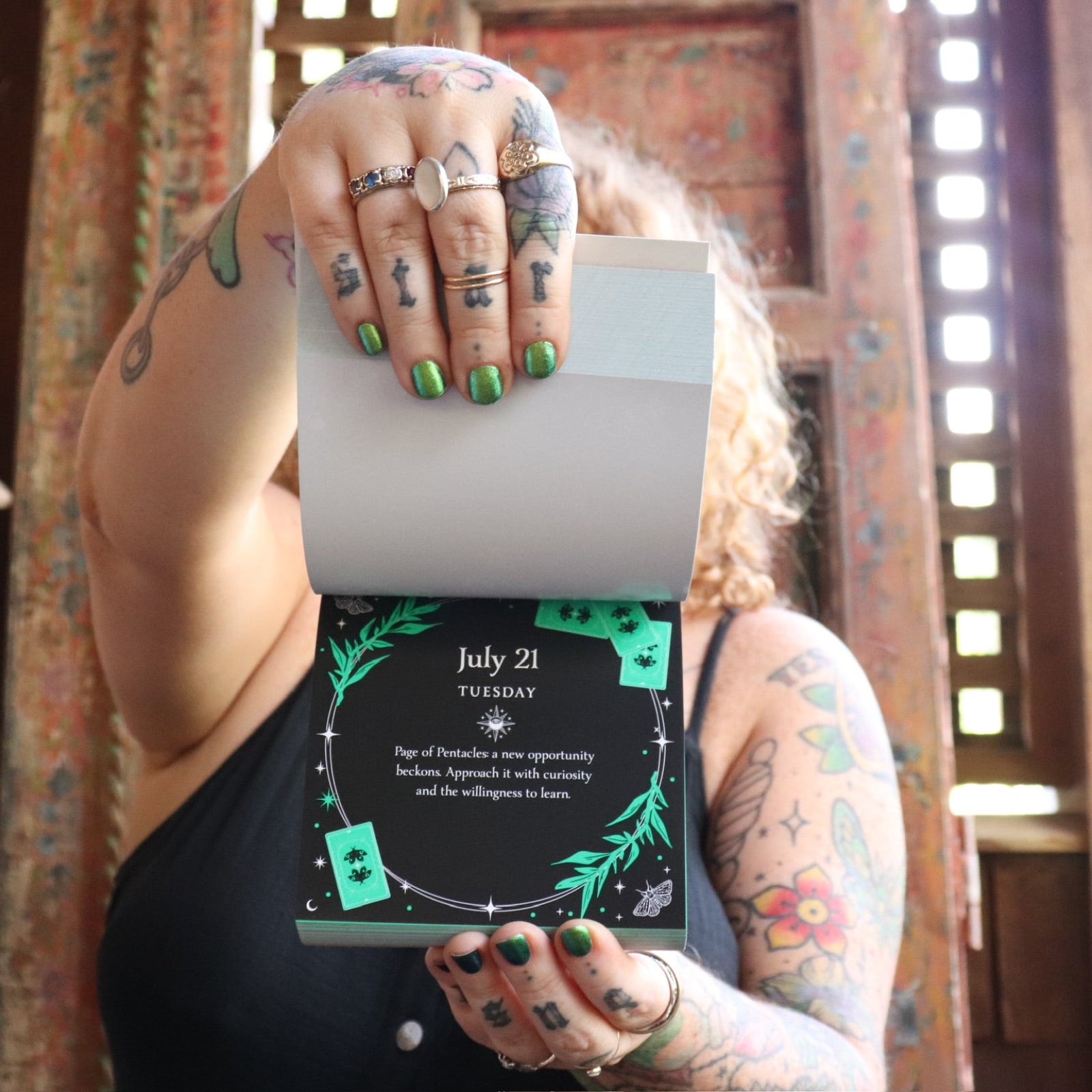 Someone holding the 2026 Witch's Calendar Daily Magick Day-to-Day Calendar, showing off the pages, showing off the pages.