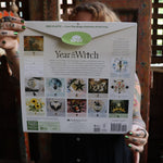 Someone holding up the Year of the Witch 2026 Wall Calendar, showing off the back