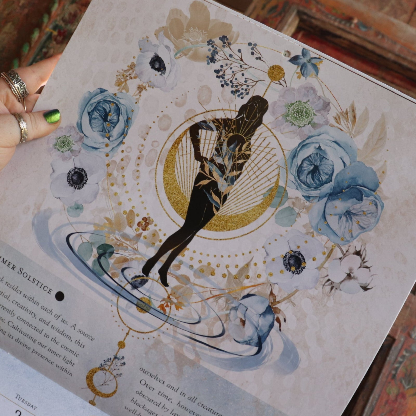 Someone holding up the Year of the Witch 2026 Wall Calendar, showing off the pages.