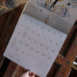 Someone holding up the Year of the Witch 2026 Wall Calendar, showing off the pages.