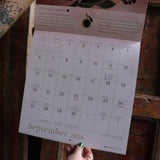 Someone holding up the Year of the Witch 2026 Wall Calendar, showing off the pages.