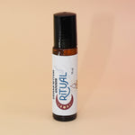The Ritual 10ml Roll-On Perfume Oil on a pink and yellow background.