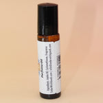 The Ritual 10ml Roll-On Perfume Oil on a pink and yellow background, showing off the back.