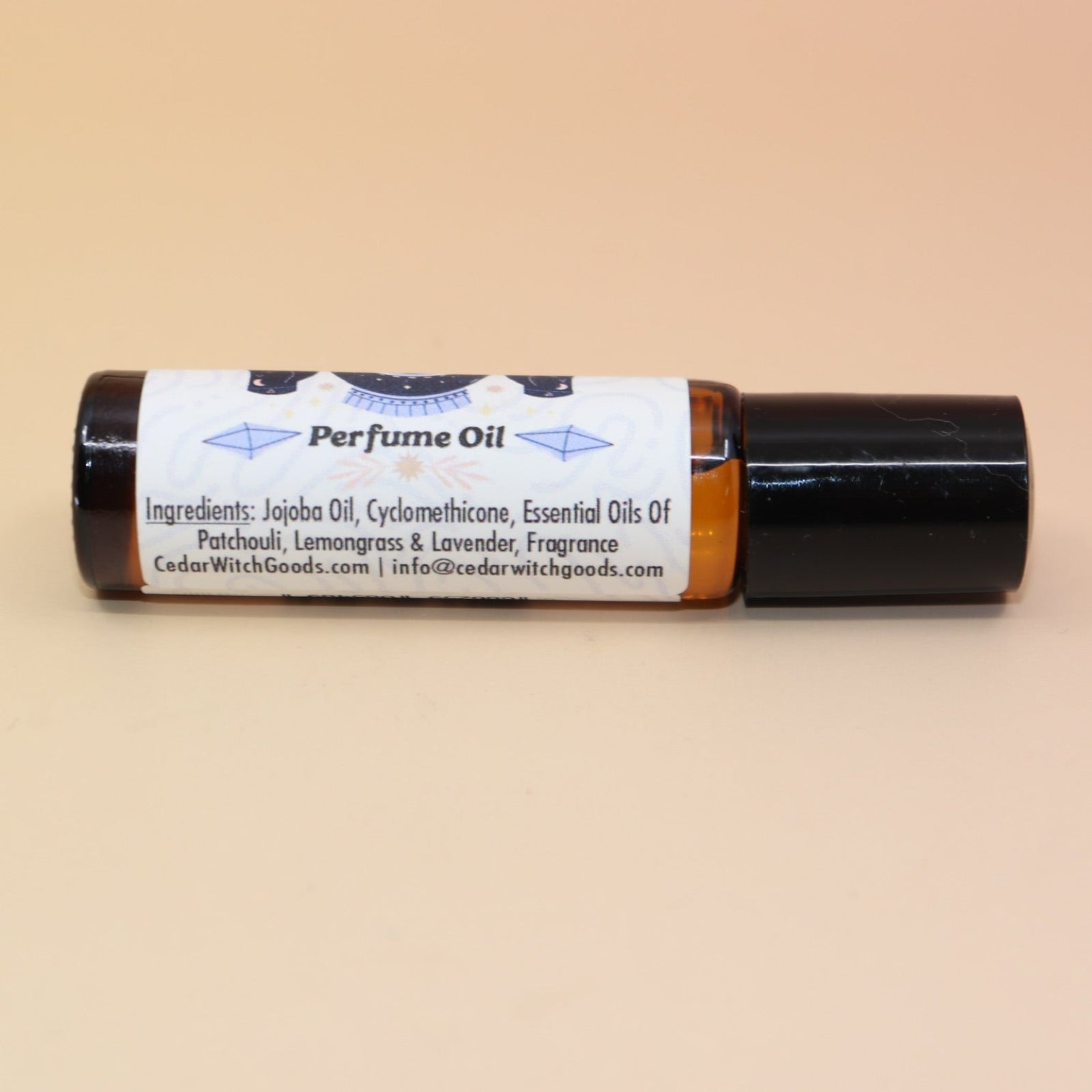 The Hippie Witch 10ml Roll-On Perfume Oil on a pink and yellow background.