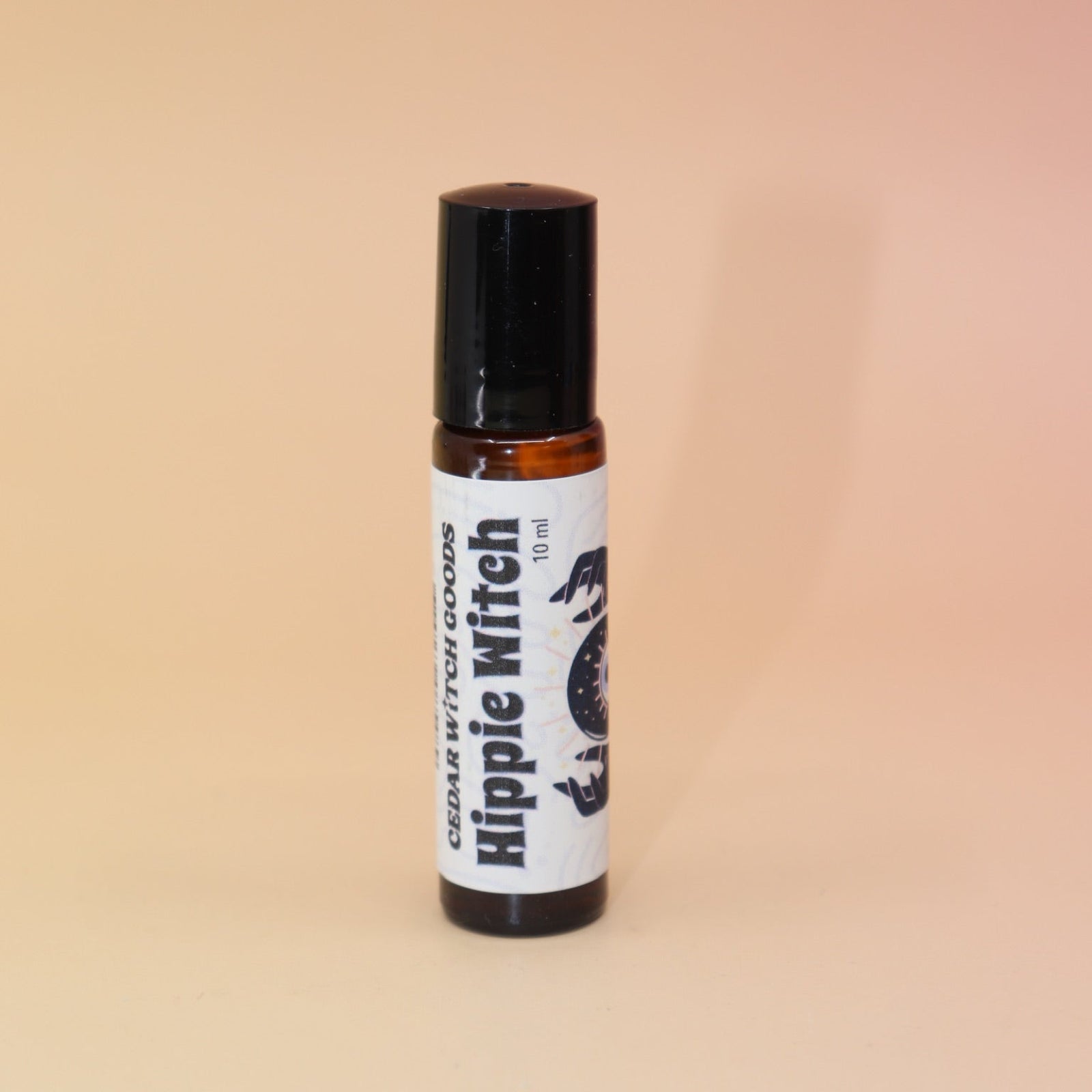 The Hippie Witch 10ml Roll-On Perfume Oil on a pink and yellow background.