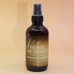 The Infinite Abundance Organic Crystal Charged Energy Spray on a pink and yellow background.