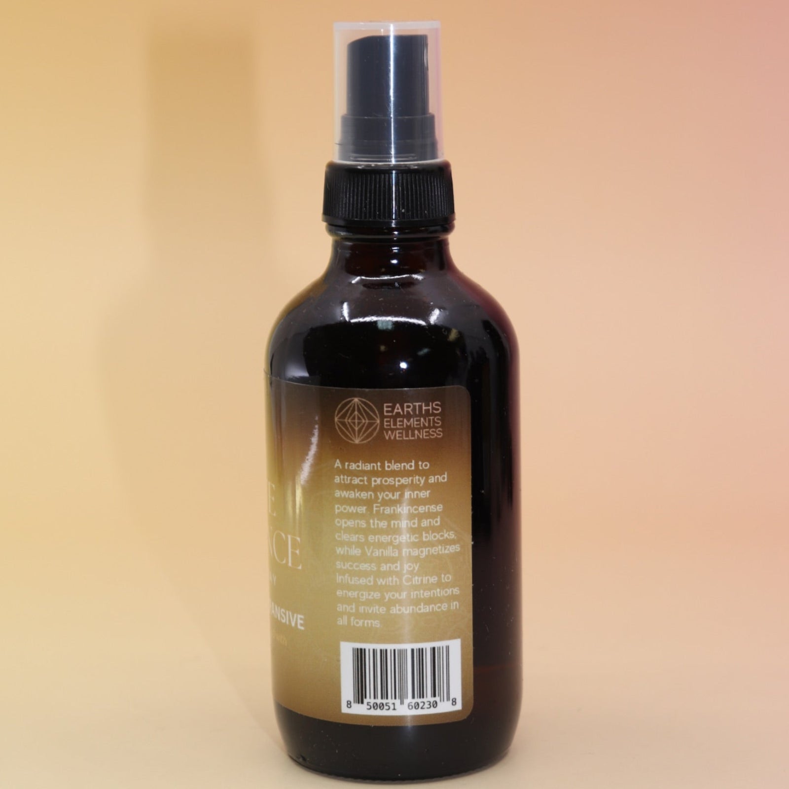 The Infinite Abundance Organic Crystal Charged Energy Spray on a pink and yellow background, showing off the side.