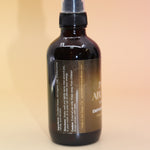 The Infinite Abundance Organic Crystal Charged Energy Spray on a pink and yellow background, showing off the side.