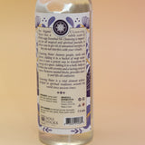 An up-close image of the back of the White Sage Spiritual Cleansing Water 7.5 oz on a pink and yellow background.