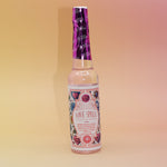 The Love Spell Spiritual Cleansing Water 7.5 oz. on a pink and yellow background.