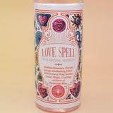 An up-close image of the Love Spell Spiritual Cleansing Water 7.5 oz. on a pink and yellow background.