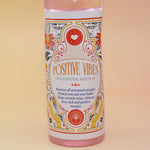 The Positive Vibes Spiritual Cleansing Water 7.5 oz on a pink and yellow background.