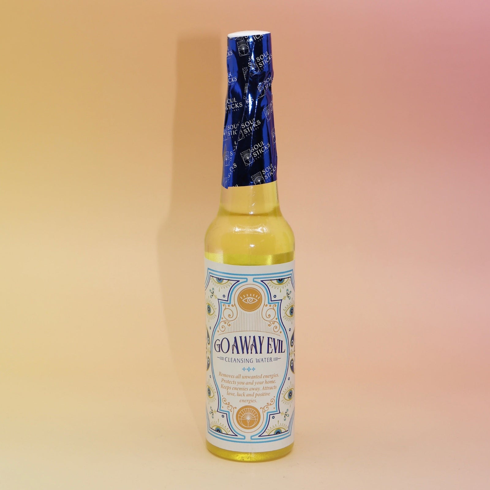The Go Away Evil Spiritual Cleansing Water 7.5 oz on a pink and yellow background.