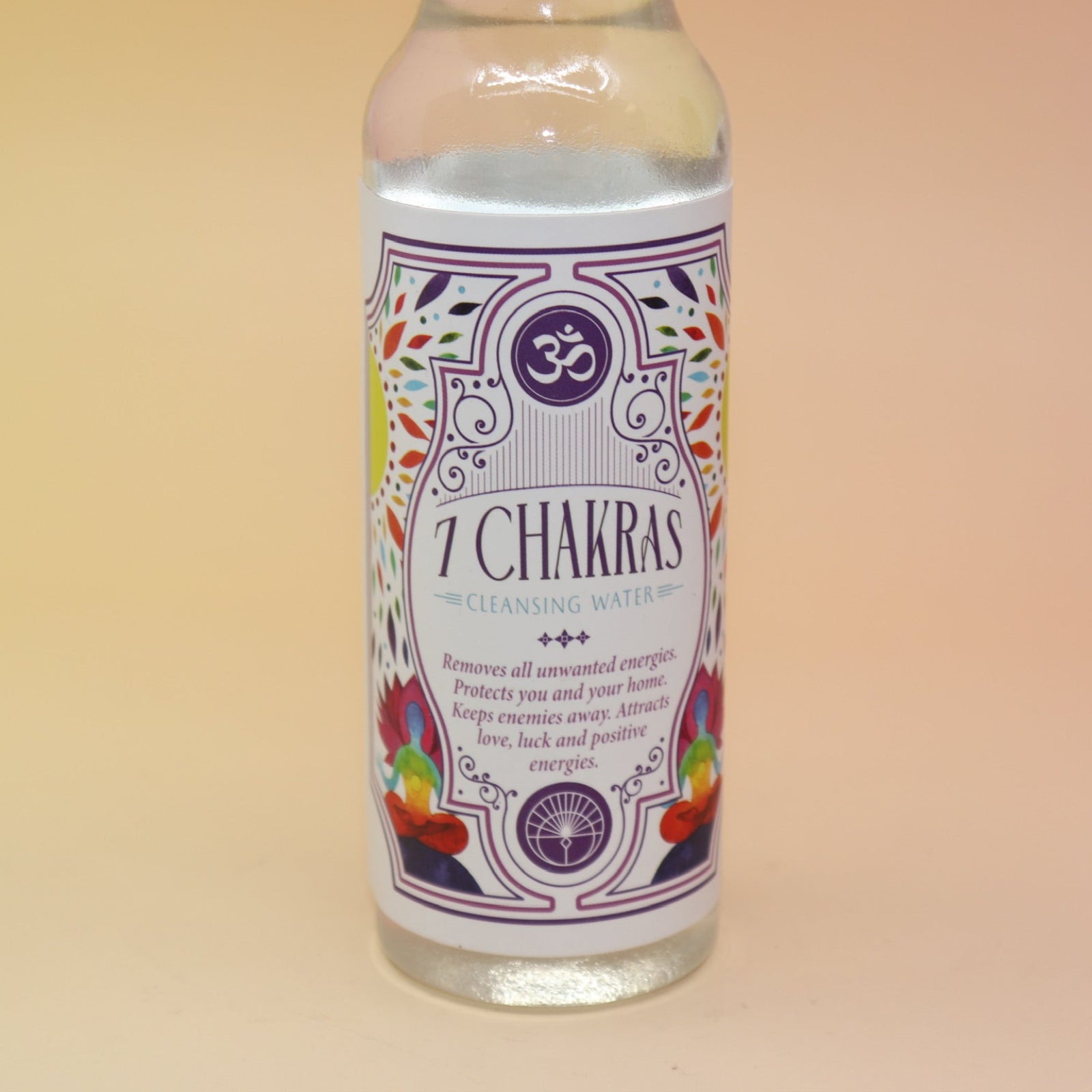 An up-close image of the 7 Chakras Spiritual Cleansing Water 7.5 oz on a pink and yellow background. 