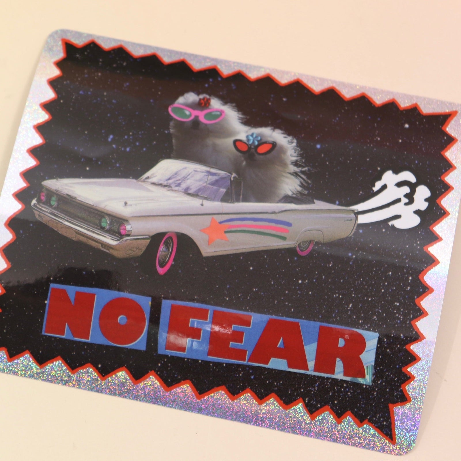 The No Fear Glitter Sticker against a crystal on a pink and yellow background. 