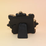 The back of the Mini Vintage Framed Print on a pink and yellow background.