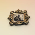 The Raccoon Mini Vintage Framed Print on a pink and yellow background.