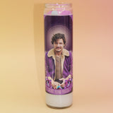 The Pedro Pascal Devotional Prayer Candle on a pink and yellow background.