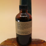 The P.F. Candle Co. Spruce - 3.5 oz Reed Diffuser on an agate slice in front of a crystal tower, showing off the back.