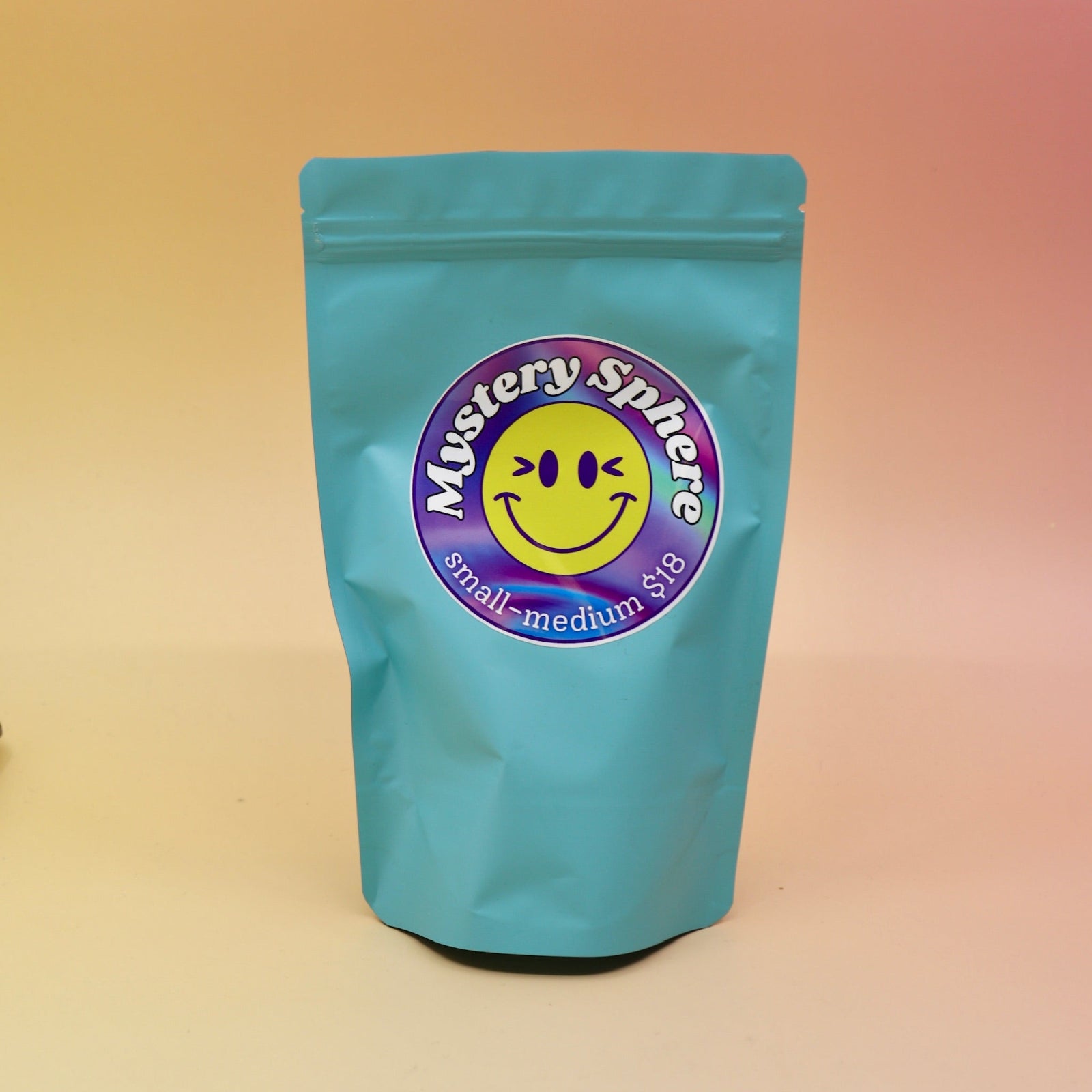 A small - medium Mystery Crystal Sphere Bag on a pink and yellow background.