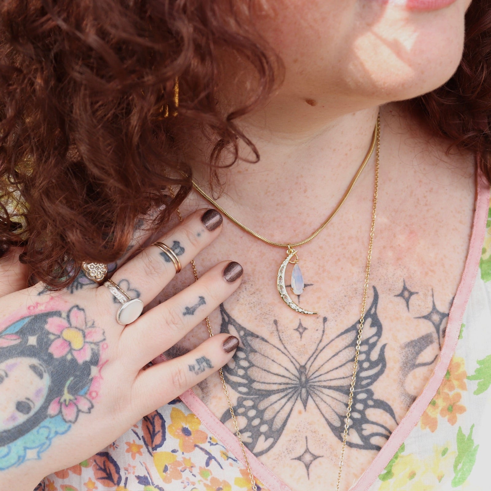 A woman wearing the Opalite Crescent Necklace – Gold Chain Crystal Moon Pendant.