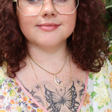 A woman wearing the Opalite Crescent Necklace – Gold Chain Crystal Moon Pendant.