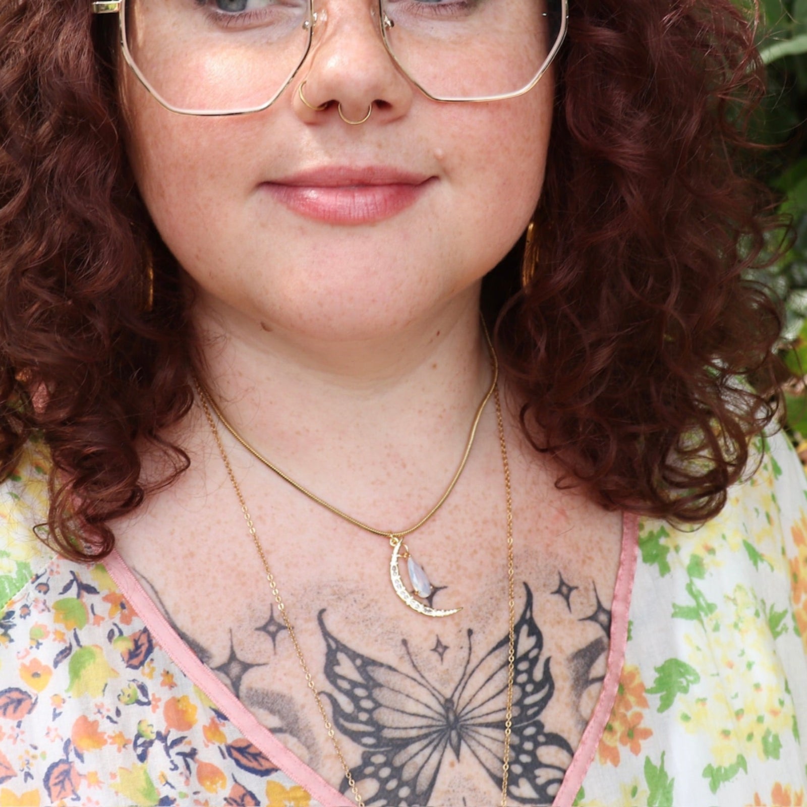 A woman wearing the Opalite Crescent Necklace – Gold Chain Crystal Moon Pendant.