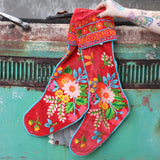 Someone holding the Set of 2 Red Floral Embroidered Stockings in front of a vintage teal Volkswagen bus.
