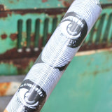 The Eye Waves Pattern Matte Fine Wrapping Paper in front of a vintage teal Volkswagen bus.