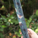 The Nouveau Twilight Butterflies Matte Fine Wrapping Paper in front of some greenery.