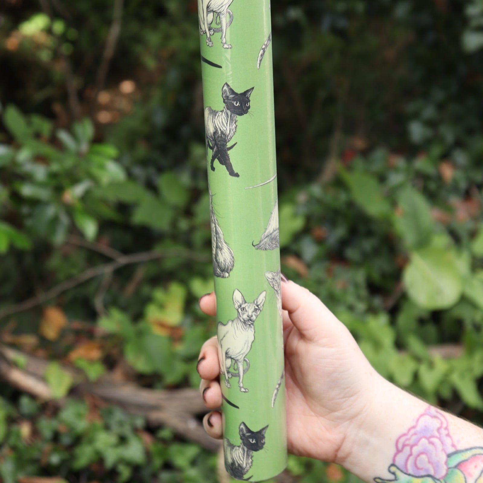 The Illustrated Cat Breeds Matte Fine Wrapping Paper in front of greenery.