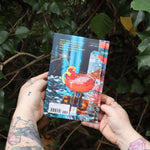 Someone holding the Disco Cocktails Hardcover Book in front of a green bush, showing off the back.