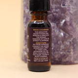 The Venus - A Love Oil Reiki Charged Anointing Oil in front of an amethyst tower all on a pink and yellow background.