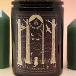 The Protection 12oz Soy Candle in front of a large crystal tower surrounded by two smaller crystals all on a pink and yellow background.
