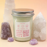 The Bubblegum Pop Glinda Soy Candle surrounded by various crystals all on a pink and yellow background, showing off the back.